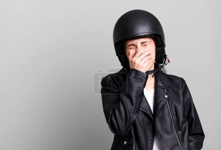 Téléchargez les photos : Young adult pretty woman. motorbike rider with leather jacket and helmet - en image libre de droit