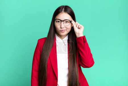 Téléchargez les photos : Young adult pretty asian businesswoman wearing red blazer and glasses - en image libre de droit