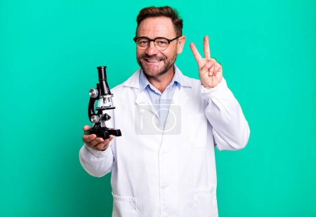 Photo for Middle age man smiling and looking friendly, showing number two. scientist concept - Royalty Free Image