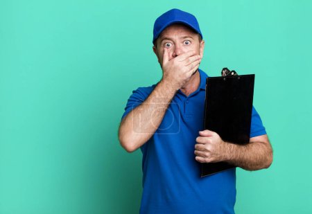 Photo for Middle age man covering mouth with hands with a shocked. company employee with an inventory - Royalty Free Image
