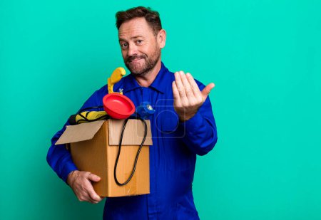 Téléchargez les photos : Middle age plumber man with a toolbox sport coach concept with a soccer ball - en image libre de droit
