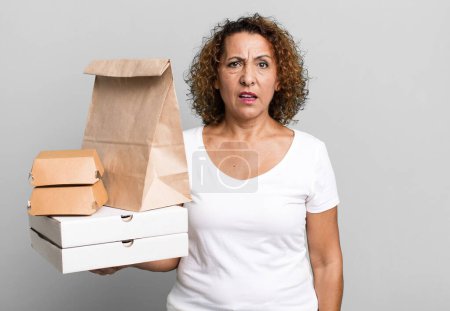 Photo for Pretty middle age woman feeling puzzled and confused. take away fast food delivery concept. - Royalty Free Image