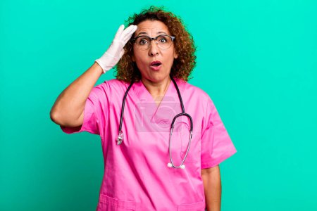 Photo for Pretty middle age woman looking happy, astonished and surprised. nurse concept - Royalty Free Image