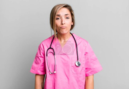 Photo for Pretty blonde woman feeling sad and whiney with an unhappy look and crying. nurse concept - Royalty Free Image