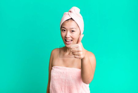 Foto de Bonita mujer asiática sentirse orgulloso, sonriendo positivamente con los pulgares hacia arriba. concepto de belleza y ducha - Imagen libre de derechos