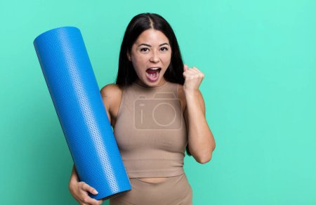 Foto de Mujer bonita hispana sintiéndose conmocionada, riendo y celebrando el éxito del concepto de yoga - Imagen libre de derechos