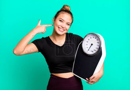 Photo for Hispanic pretty woman smiling confidently pointing to own broad smile. fitness and diet concept - Royalty Free Image