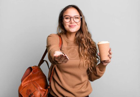 Photo for Hispanic pretty woman smiling happily with friendly and  offering and showing a concept. take away coffee concept - Royalty Free Image