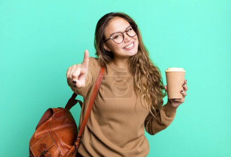 Photo for Hispanic pretty woman smiling proudly and confidently making number one. take away coffee concept - Royalty Free Image