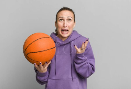 Photo for Young pretty woman looking desperate, frustrated and stressed. basketball concept - Royalty Free Image