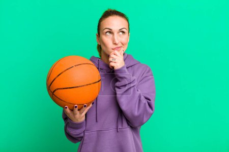 Photo for Young pretty woman thinking, feeling doubtful and confused. basketball concept - Royalty Free Image