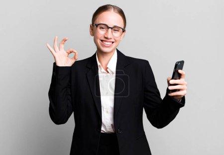 Téléchargez les photos : Blonde pretty young caucasian business woman using her smartphone - en image libre de droit