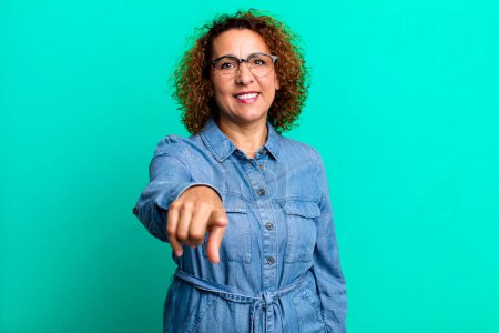 Photo for Middle age hispanic woman pointing at camera with a satisfied, confident, friendly smile, choosing you - Royalty Free Image
