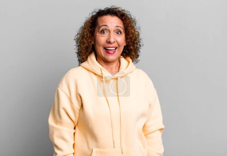 Photo for Middle age hispanic woman looking happy and pleasantly surprised, excited with a fascinated and shocked expression - Royalty Free Image