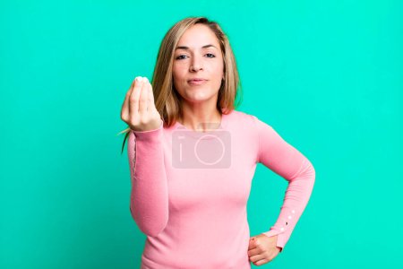 Foto de Blonde adult woman making capice or money gesture, telling you to pay your debts! - Imagen libre de derechos