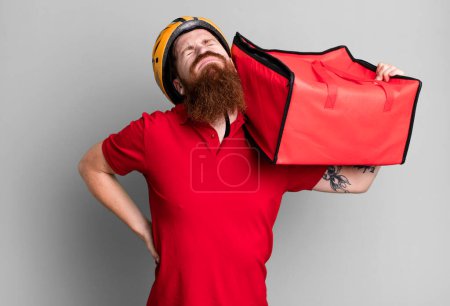 Téléchargez les photos : Jeune adulte cheveux roux barbu cool livreur de pizza homme - en image libre de droit
