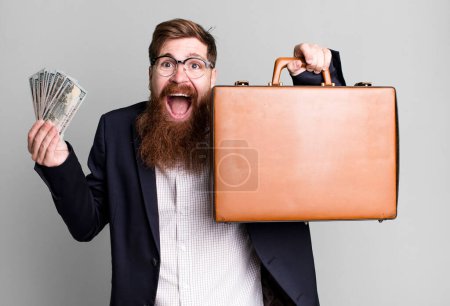 Foto de Joven adulto pelo rojo barbudo fresco hombre de negocios con una maleta de cuero - Imagen libre de derechos