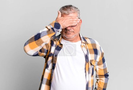 Photo for Middle age senior man covering eyes with one hand feeling scared or anxious, wondering or blindly waiting for a surprise - Royalty Free Image