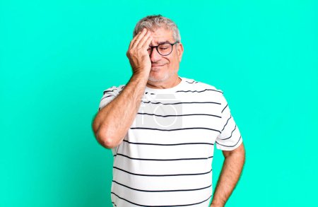 Photo for Middle age senior man looking sleepy, bored and yawning, with a headache and one hand covering half the face - Royalty Free Image