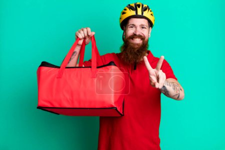 Photo for Long beard man smiling and looking happy, gesturing victory or peace. pizza delivery concept - Royalty Free Image