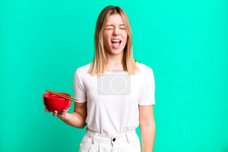 Photo for Young pretty woman shouting aggressively, looking very angry. japanese ramen noodles concept - Royalty Free Image