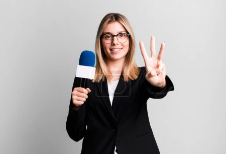 Photo for Young pretty woman smiling and looking friendly, showing number three. presenter or journalist concept - Royalty Free Image