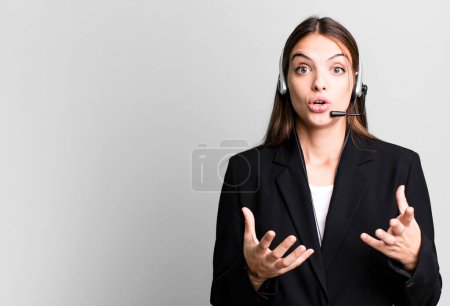 Photo for Young pretty woman amazed, shocked and astonished with an unbelievable surprise. telemarketing agent concept - Royalty Free Image