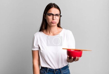 Photo for Young pretty woman feeling sad and whiney with an unhappy look and crying. japanese ramen noodles concept - Royalty Free Image