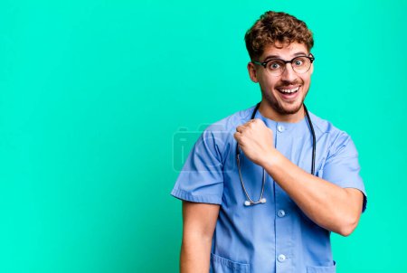 Photo for Young adult caucasian man feeling happy and facing a challenge or celebrating. nurse concept - Royalty Free Image