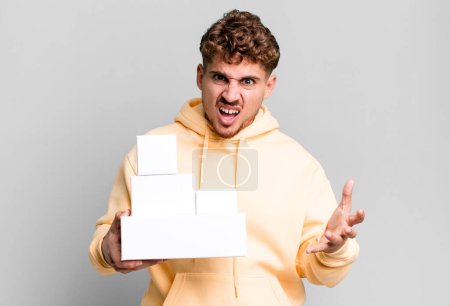 Photo for Young adult caucasian man looking angry, annoyed and frustrated. blank different packages concept - Royalty Free Image