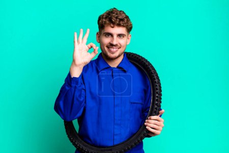 Foto de Joven adulto caucásico hombre sintiéndose feliz, mostrando aprobación con buen gesto. reparador de bicicletas o concepto mecánico - Imagen libre de derechos