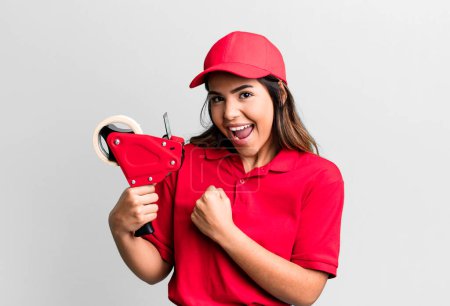 Photo for Hispanic pretty woman feeling happy and facing a challenge or celebrating. packer and delivery employee - Royalty Free Image