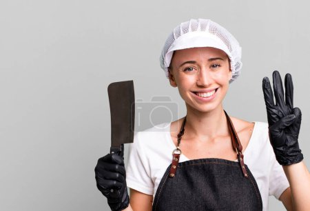 Photo for Smiling and looking friendly, showing number three. butcher concept - Royalty Free Image