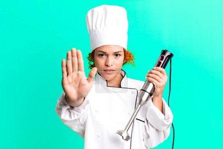 Foto de Pelo rojo bastante chef mujer con un mezclador de manos - Imagen libre de derechos