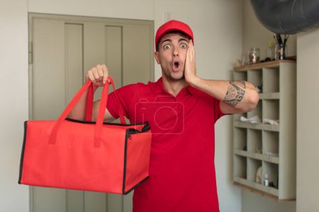 Photo for Young handsome man feeling extremely shocked and surprised. pizza delivery concept - Royalty Free Image