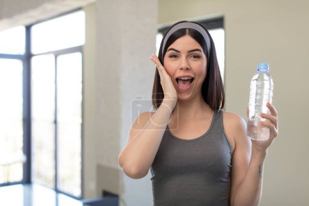 Téléchargez les photos : Jolie jeune femme se sentant heureuse et étonnée de quelque chose d'incroyable. concept de bouteille d'eau - en image libre de droit