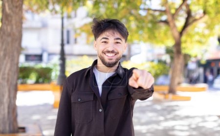 Photo for Young handsome man pointing at camera with a satisfied, confident, friendly smile, choosing you - Royalty Free Image