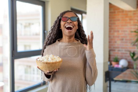 Téléchargez les photos : Noir afro femme crier avec les mains en l'air avec popcorns - en image libre de droit