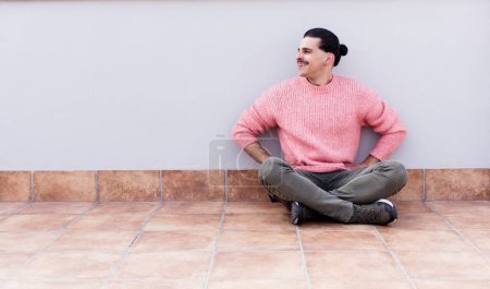 Photo for Young handsome man sitting on the floors with a copyspace - Royalty Free Image
