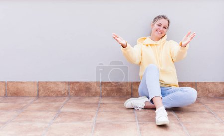 Photo for Pretty caucasian sitting  woman smiling cheerfully giving a warm, friendly, loving welcome hug, feeling happy and adorable - Royalty Free Image