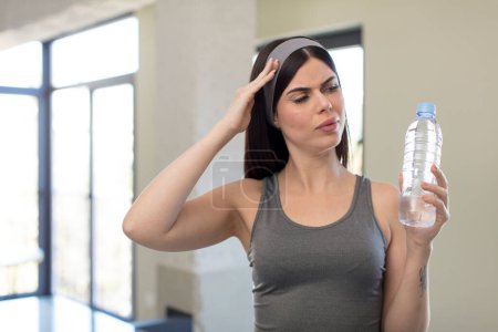 Photo for Pretty young woman looking surprised, realizing a new thought, idea or concept. water bottle concept - Royalty Free Image