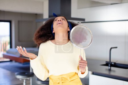 Foto de Mujer negra bastante afro gritando con las manos arriba en el aire. concepto de chef casero - Imagen libre de derechos