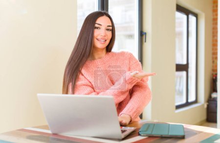 Téléchargez les photos : Jolie jeune femme avec un ordinateur portable sur un bureau à la maison - en image libre de droit
