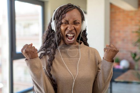 Foto de Negro afro mujer buscando enojado, molesto y frustrado. escuchar música concepto - Imagen libre de derechos