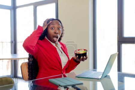 Photo for Black afro woman feeling extremely shocked and surprised. telecommuting concept - Royalty Free Image