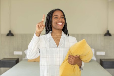 Foto de Negro afro mujer sintiéndose como un feliz y emocionado genio después de darse cuenta de una idea. concepto de descanso y ropa de dormir - Imagen libre de derechos