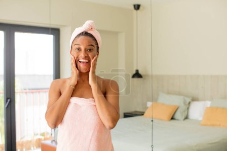 Téléchargez les photos : Afro noir femme se sentant heureux et étonné de quelque chose d'incroyable. concept de peignoir - en image libre de droit