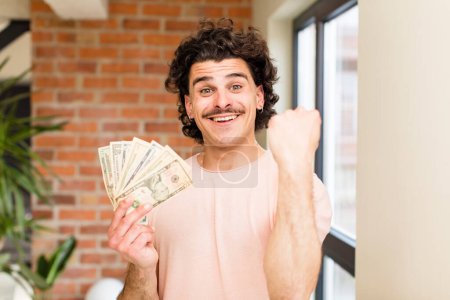 Foto de Joven hombre guapo con billetes de dólar en el interior de casa - Imagen libre de derechos