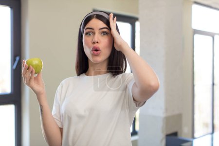 Photo for Pretty young woman feeling extremely shocked and surprised. apple concept - Royalty Free Image