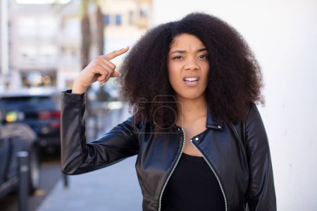 Téléchargez les photos : Afro-américaine jolie femme se sentant confus et perplexe, montrant que vous êtes fou, fou ou hors de votre esprit - en image libre de droit
